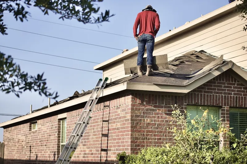 Professional roofer working on a residential roof in Painesville